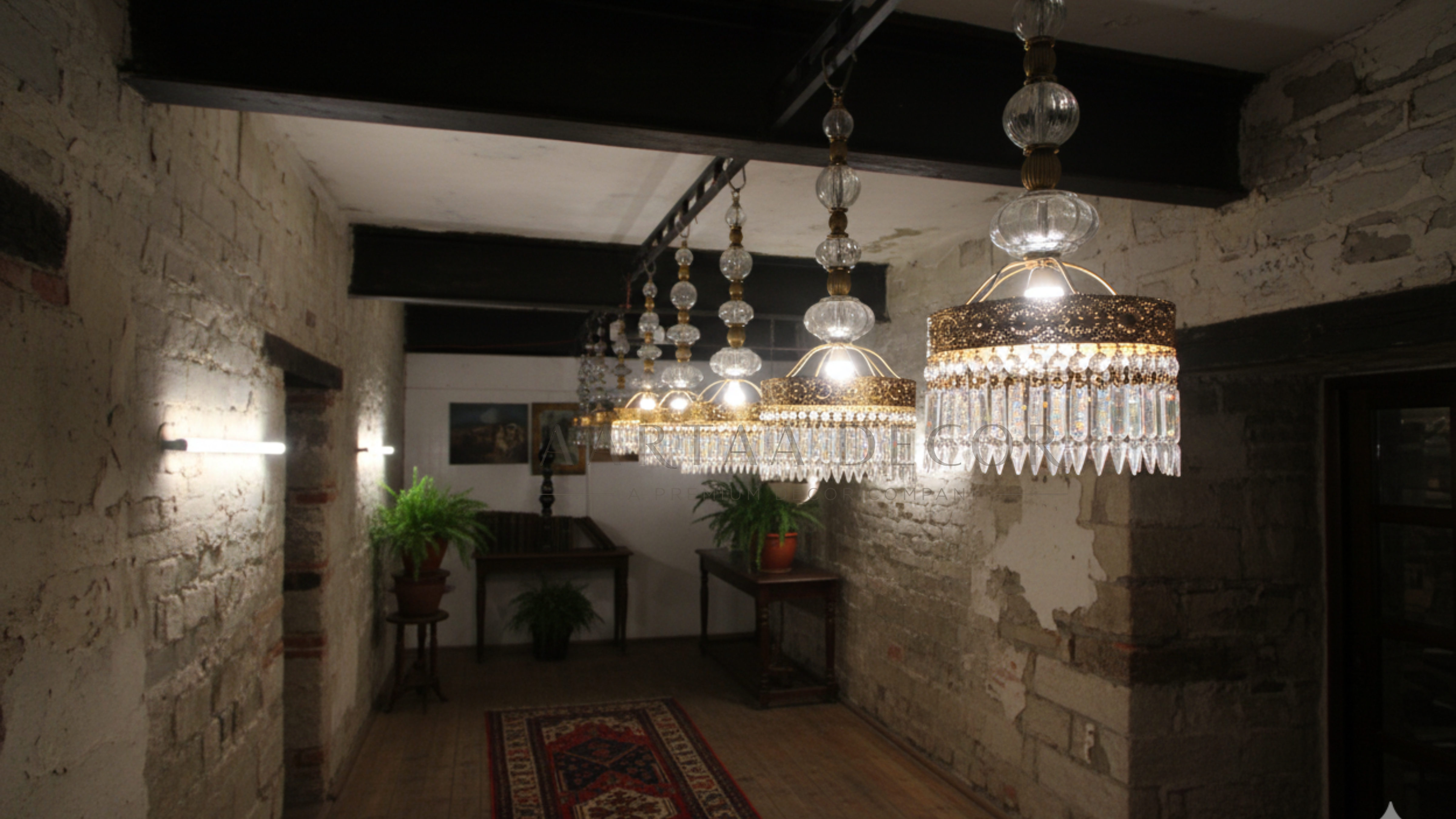 Dining room with stone walls, chandeliers, and a table.