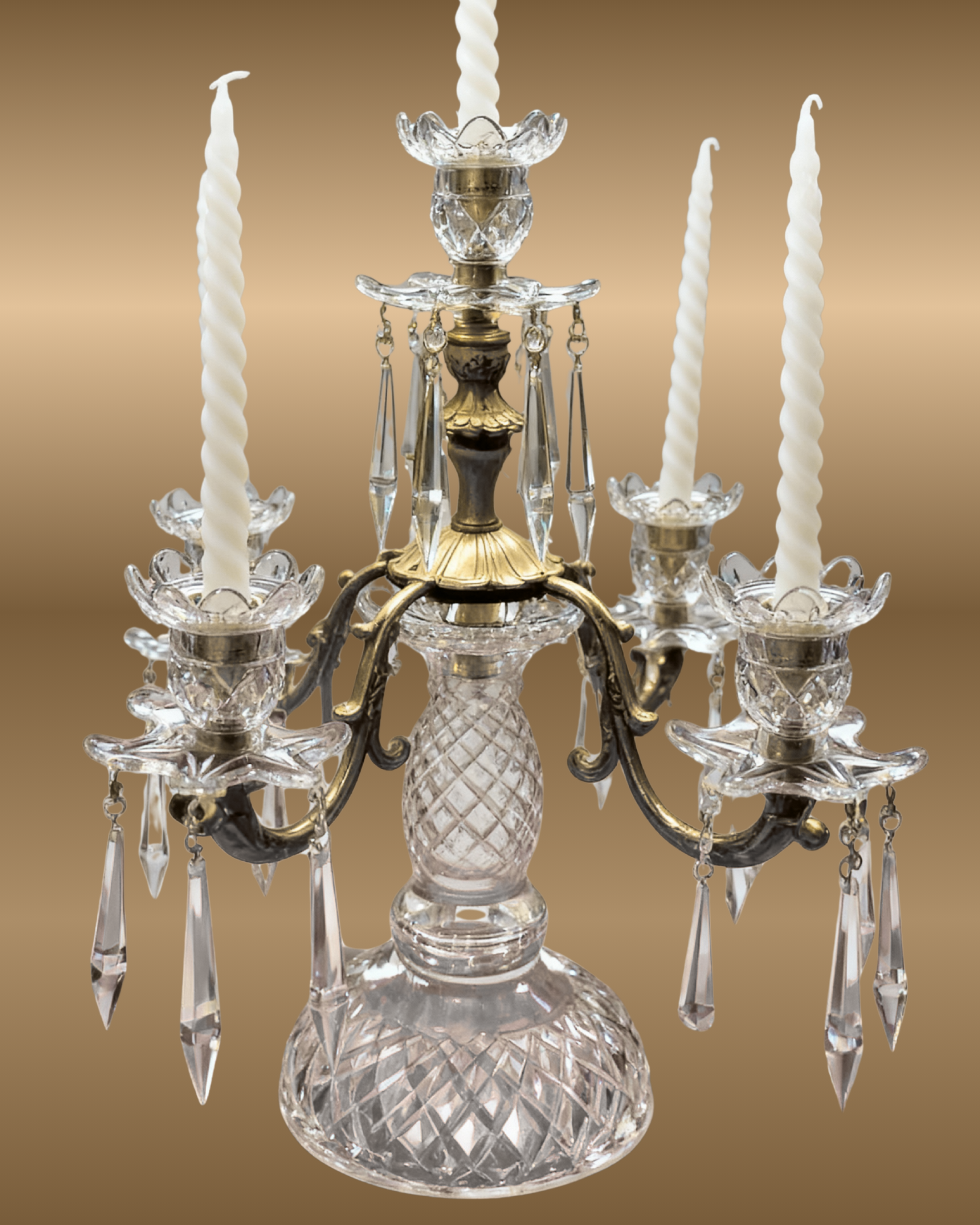 Decorative crystal candelabrum with white candles on a brown background