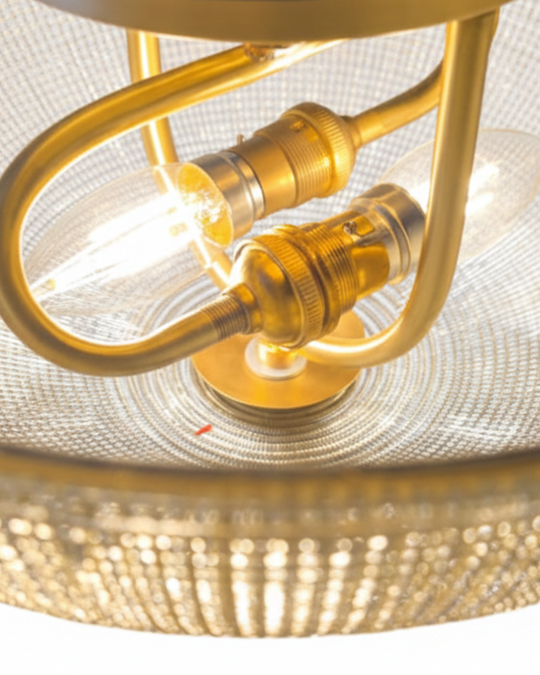 Close-up of a gold lamp with a blurred background. Discover Aurelia Bowl Luxe Pendant Light by AartaaDecor. Handcrafted solid brass & textured glass pendant, made in India.