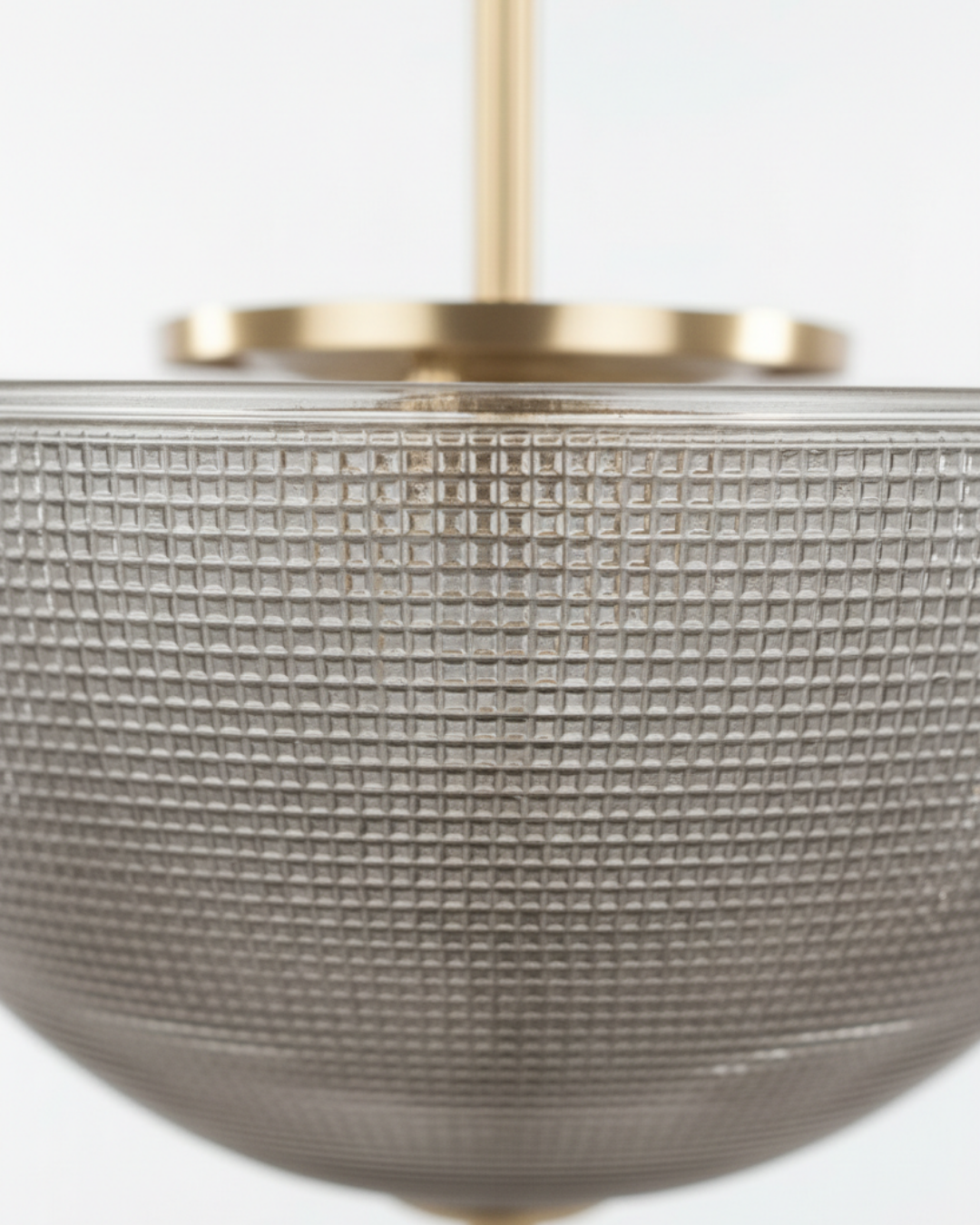 Close-up of a textured pendant light with a gold fixture on a white background. Discover Aurelia Bowl Luxe Pendant Light by AartaaDecor. Handcrafted solid brass & textured glass pendant, made in India.