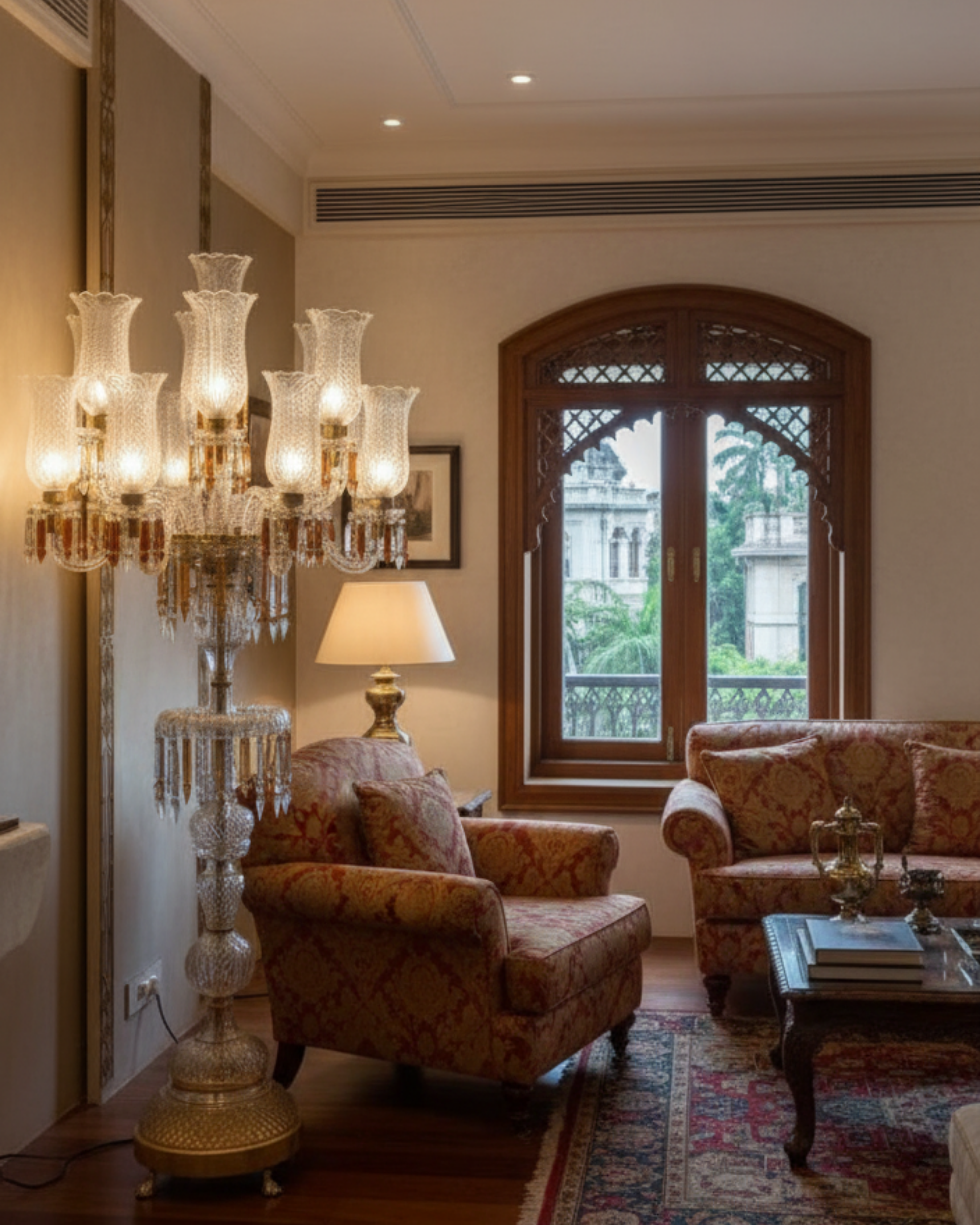 Luxurious living room with ornate chandelier and armchairs.