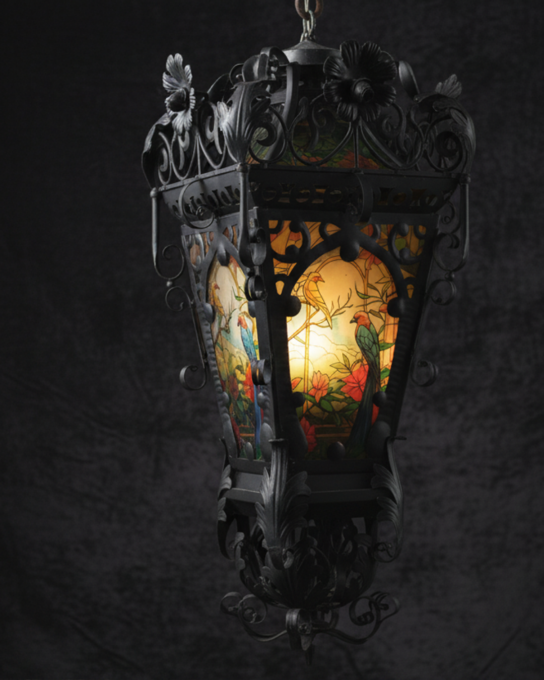 Decorative hanging lantern with stained glass design on a dark background