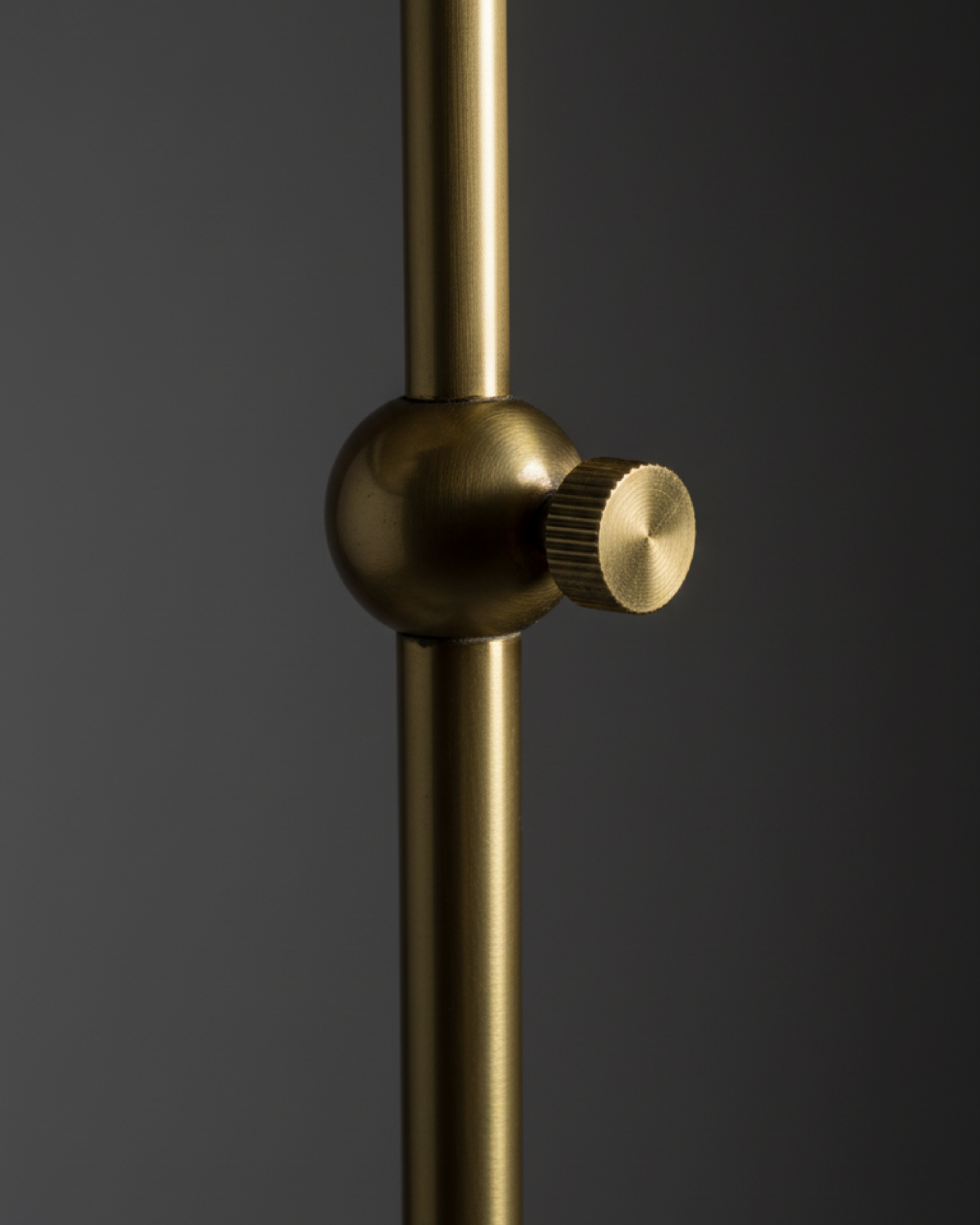 Gold shower head with a knob on a dark background
