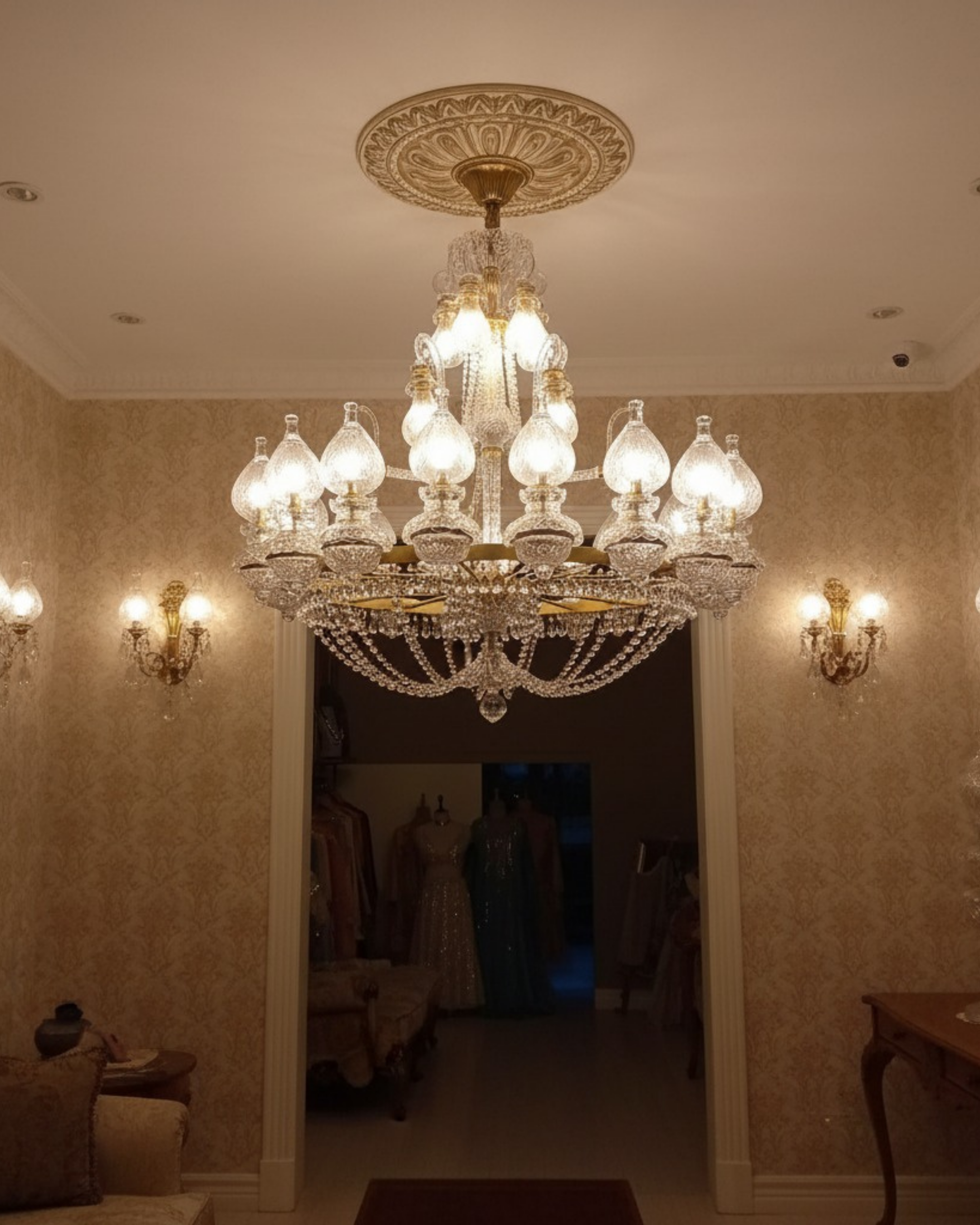 Elysian Flame 28-Light Grand Crystal Chandelier in a luxury living room with high ceilings, gilded brass frame and cascading crystals.