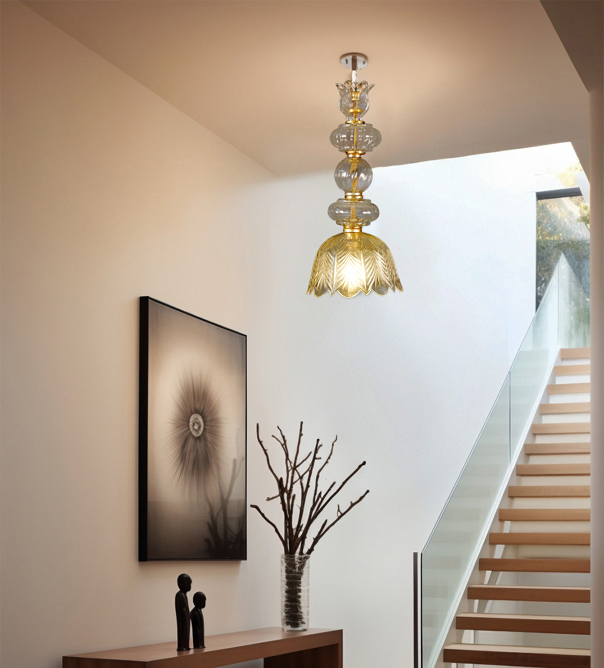 Glass and gold pendant light with intricate leaf motif, featuring elegant hanging design in a modern staircase area.