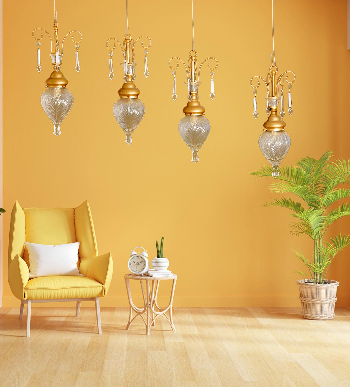 Elegant gold and glass teardrop pendant lights with crystal accents, hanging in a stylish room with yellow walls and a cozy yellow armchair.