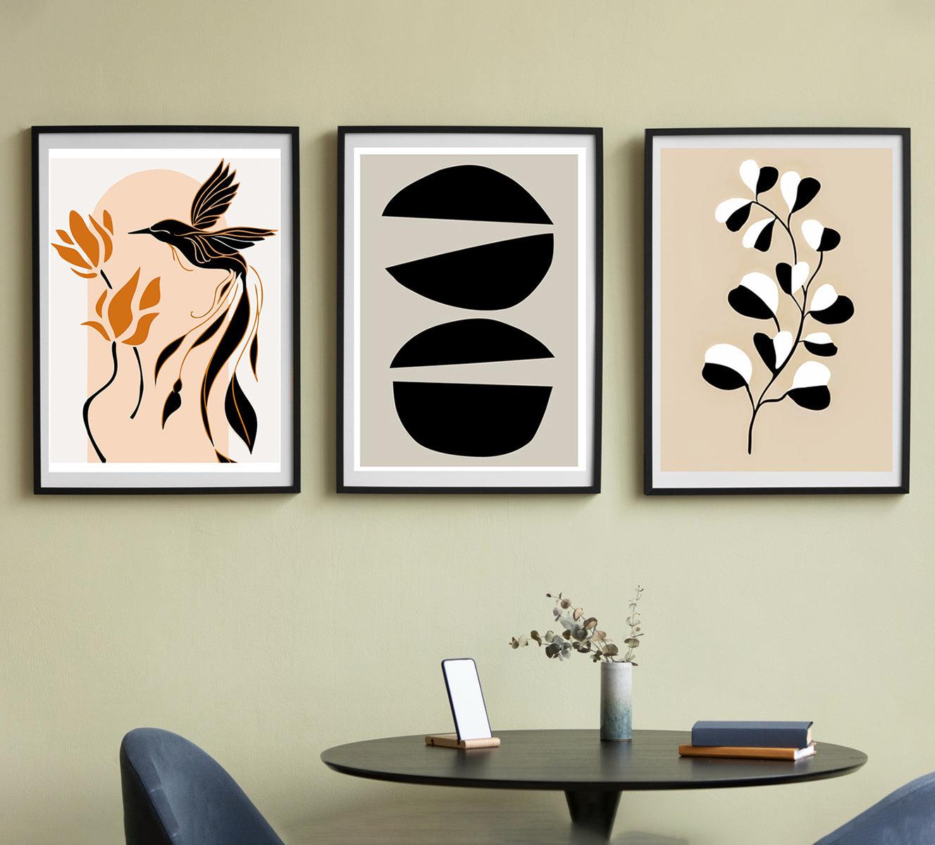 Set of three minimalist botanical wall art prints in black and earthy tones, featuring abstract shapes and botanical elements on canvas, perfect for modern home or office decor.