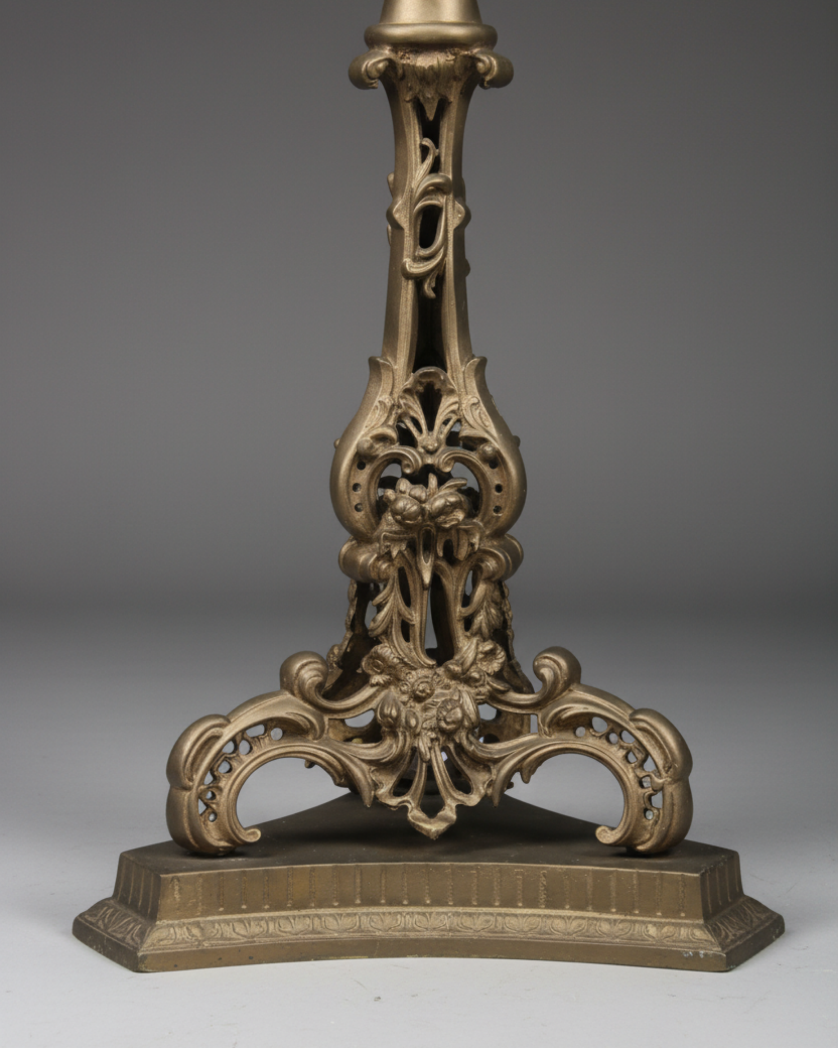 Decorative bronze lamp base on a gray background