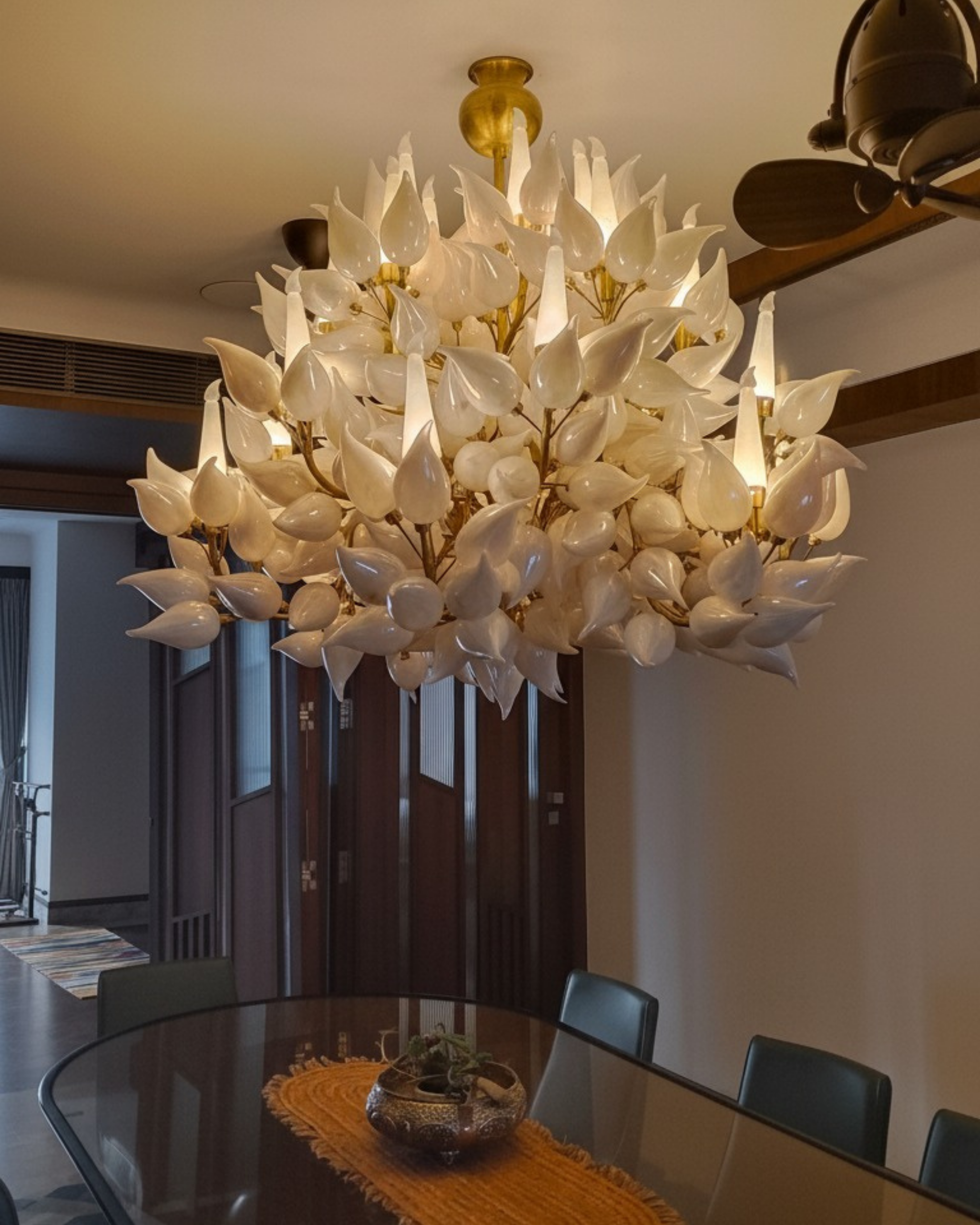 Luxury dining room featuring the Radiant Petal Cascade Chandelier with 18 warm lights, elegant round table, and premium blue wall decor.