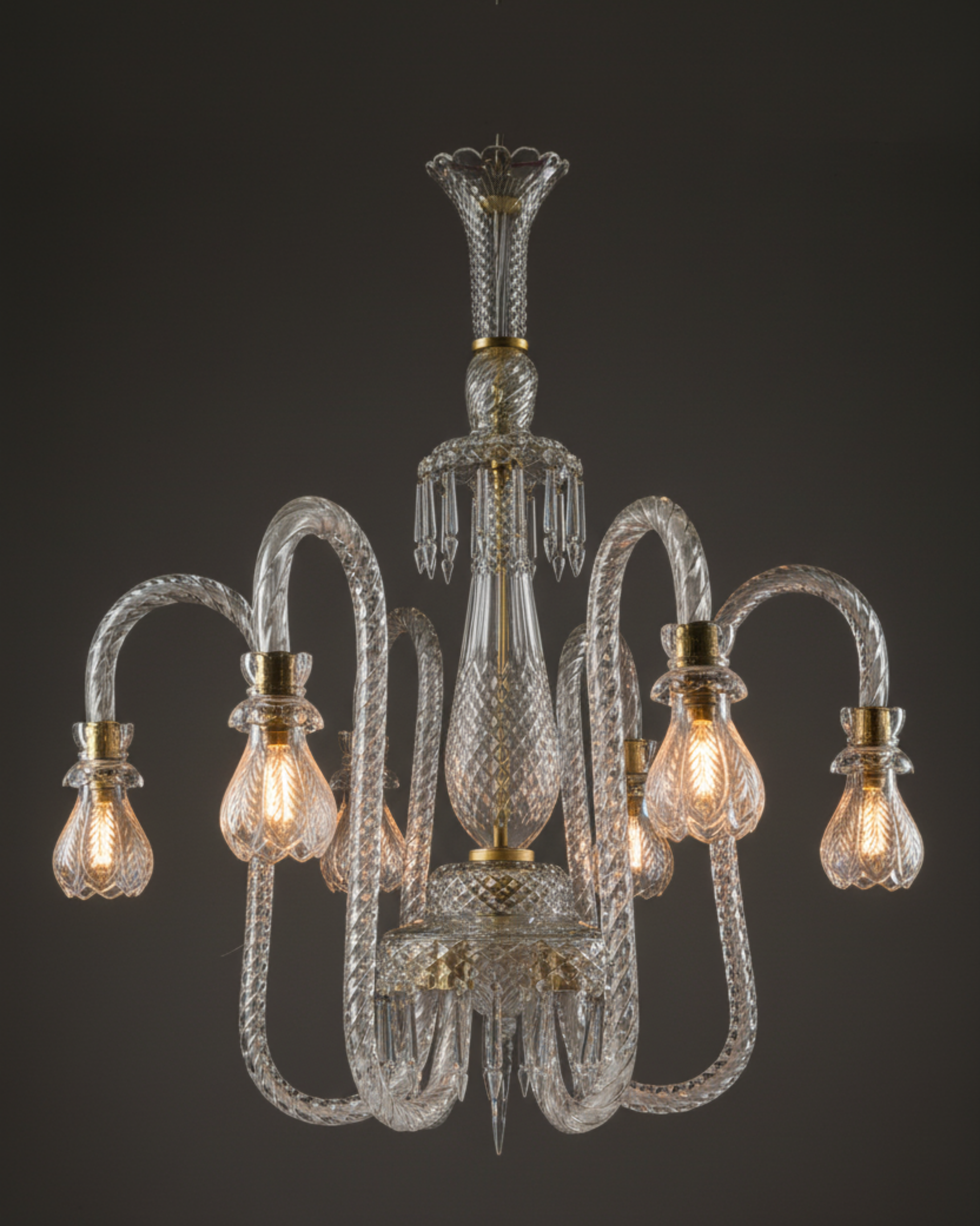 Crystal chandelier with clear glass and gold accents on a dark background