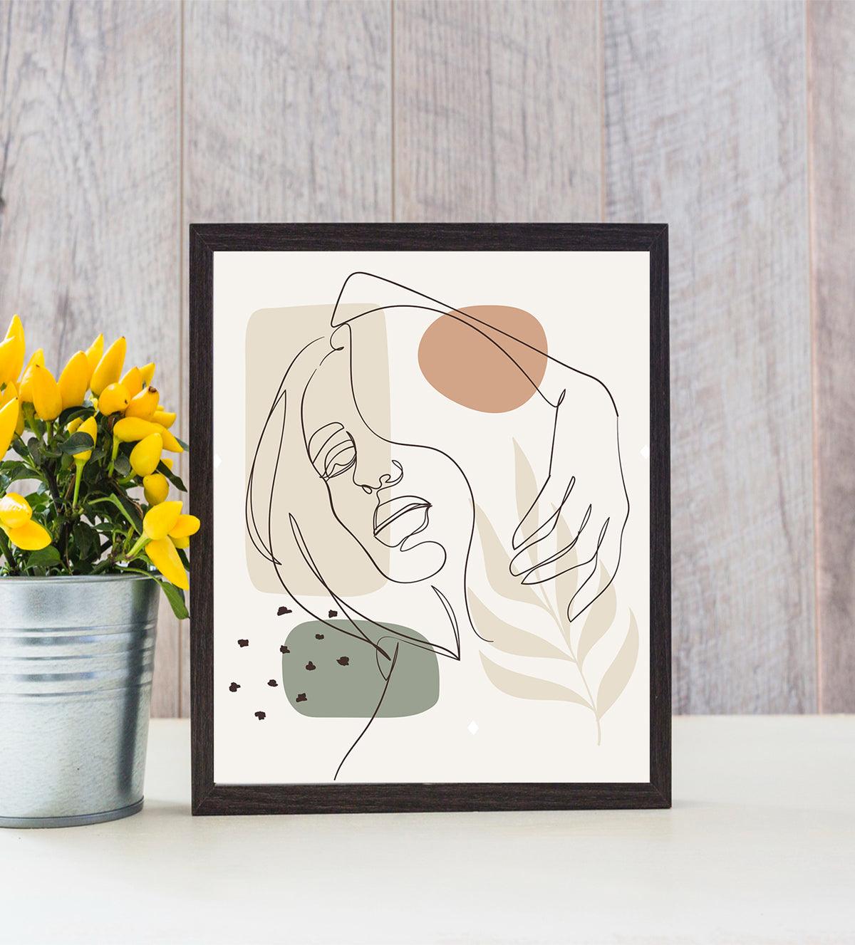 Minimalist line art of a woman’s face with abstract earthy shapes, in a calming and introspective pose, displayed in a framed artwork against a softly lit background