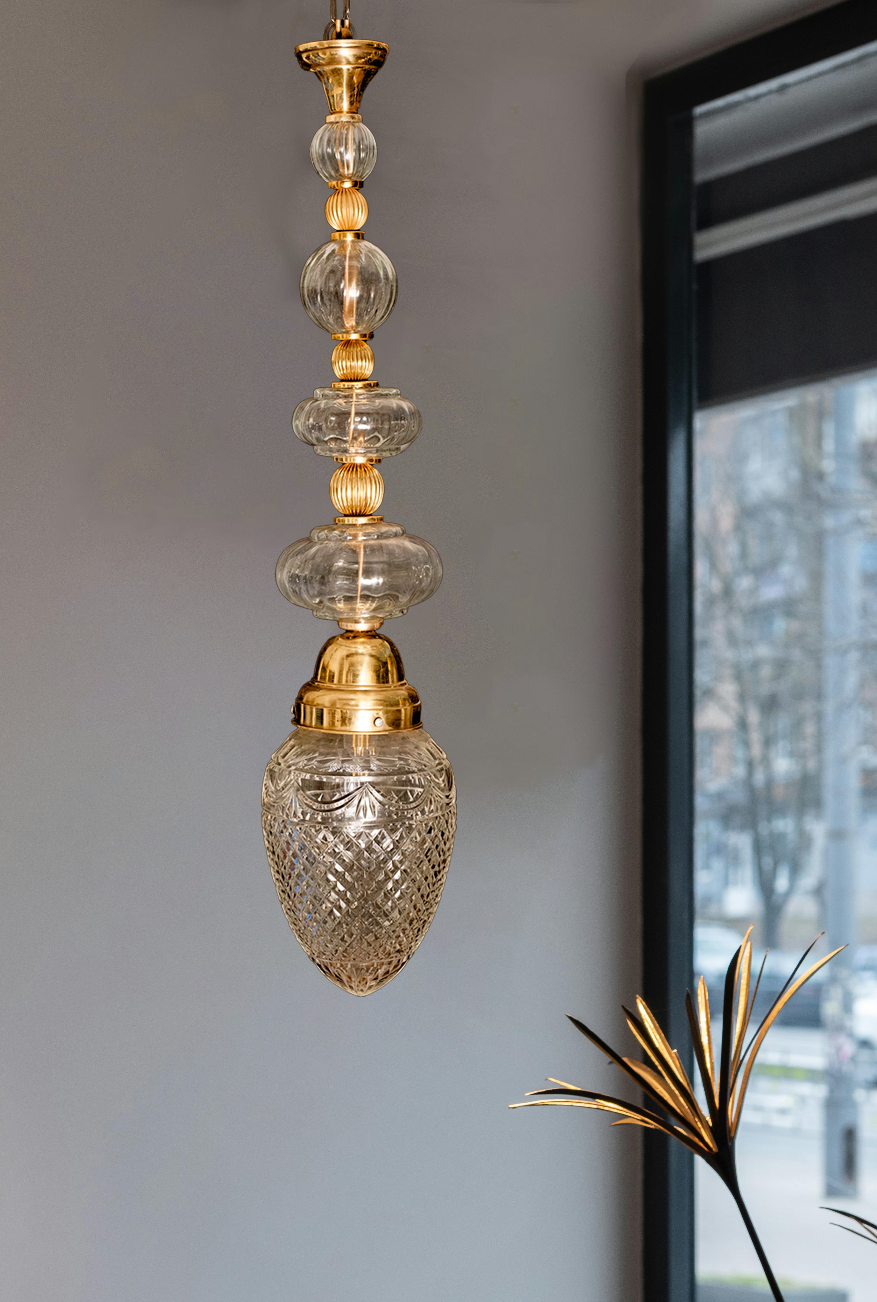 Imperial Brass Crystal Pendant Light with intricate brass accents and shimmering crystal globes, creating a luxurious, warm ambiance ideal for high-ceiling spaces.