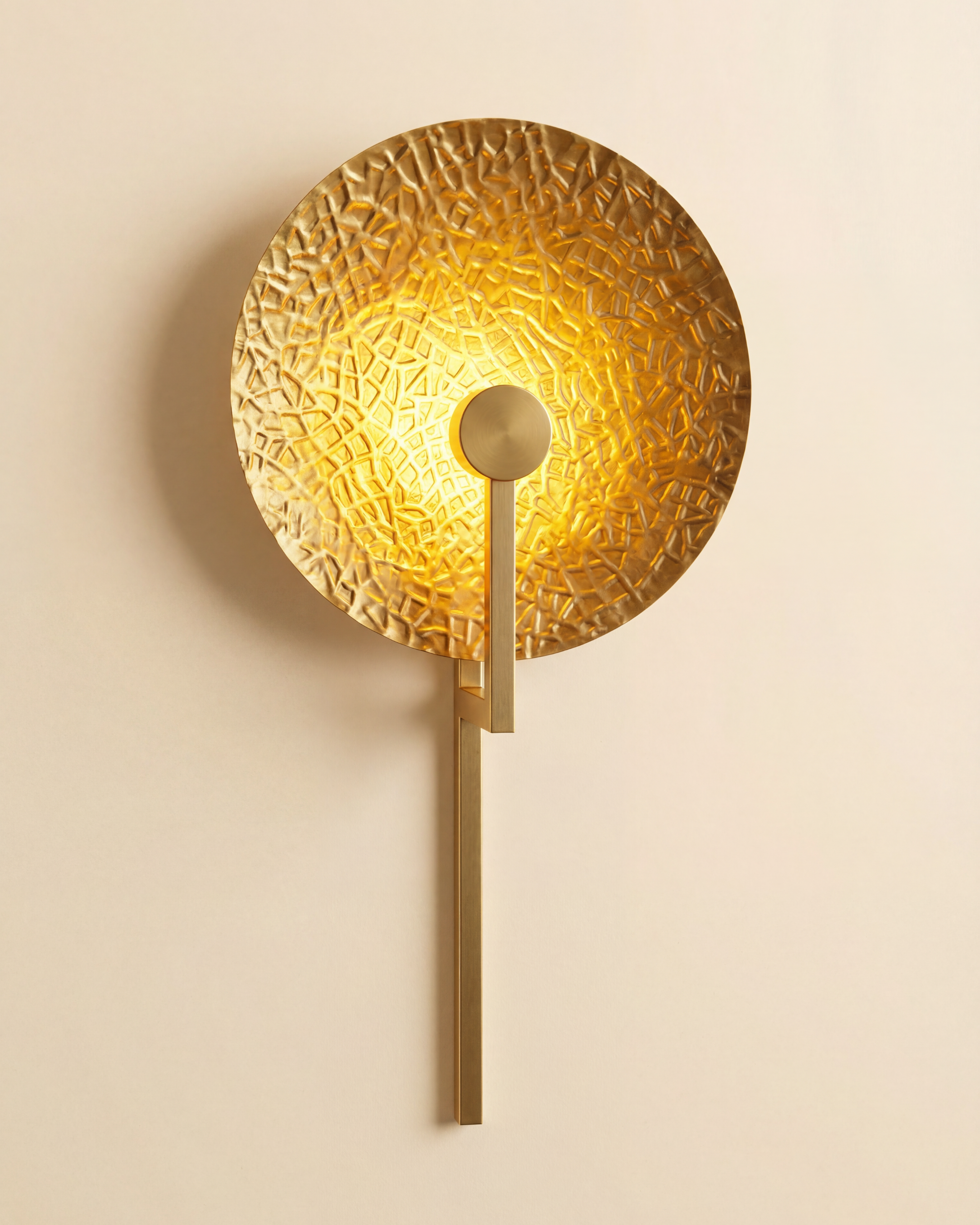 Aaranya Halo Wall Light Handcrafted Solid Brass Designer Wall Sconce | Made in India Gold wall sconce with textured design on a beige wall