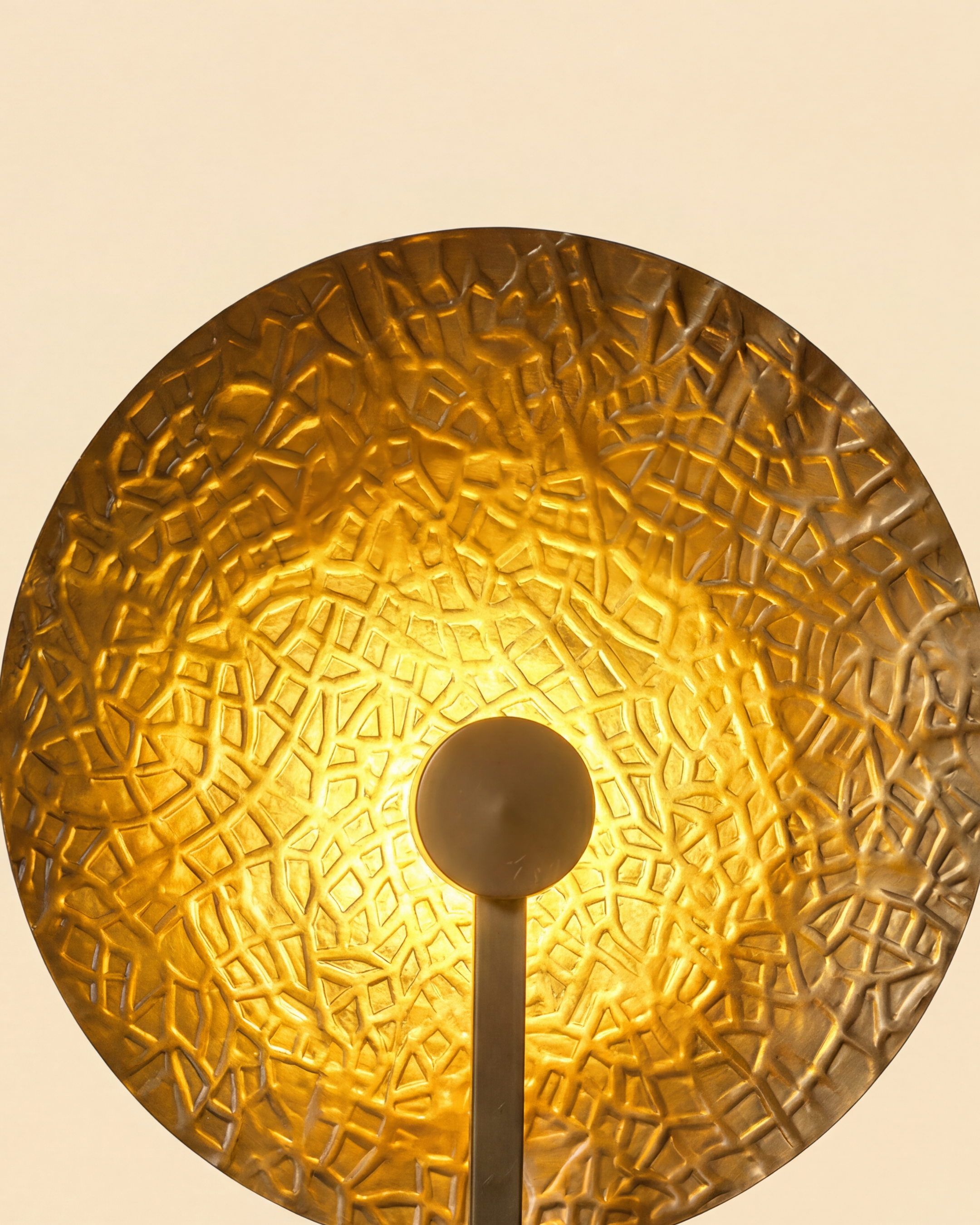 Aaranya Halo Wall Light Handcrafted Solid Brass Designer Wall Sconce | Made in India Gold textured wall sconce on a beige background