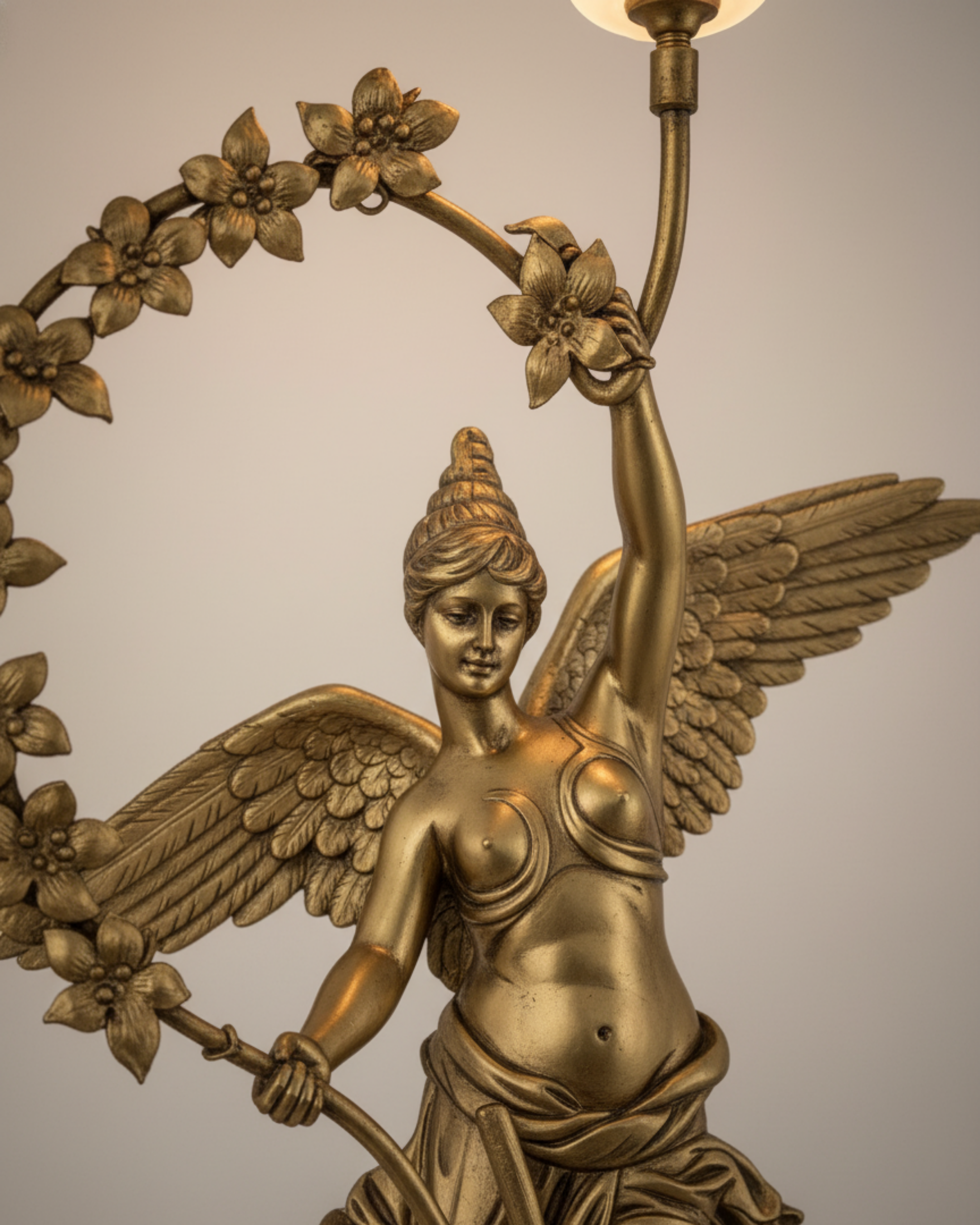 Devika Royale Celestial Wall Sconce Bronze angel statue holding a wreath and a candle against a neutral background