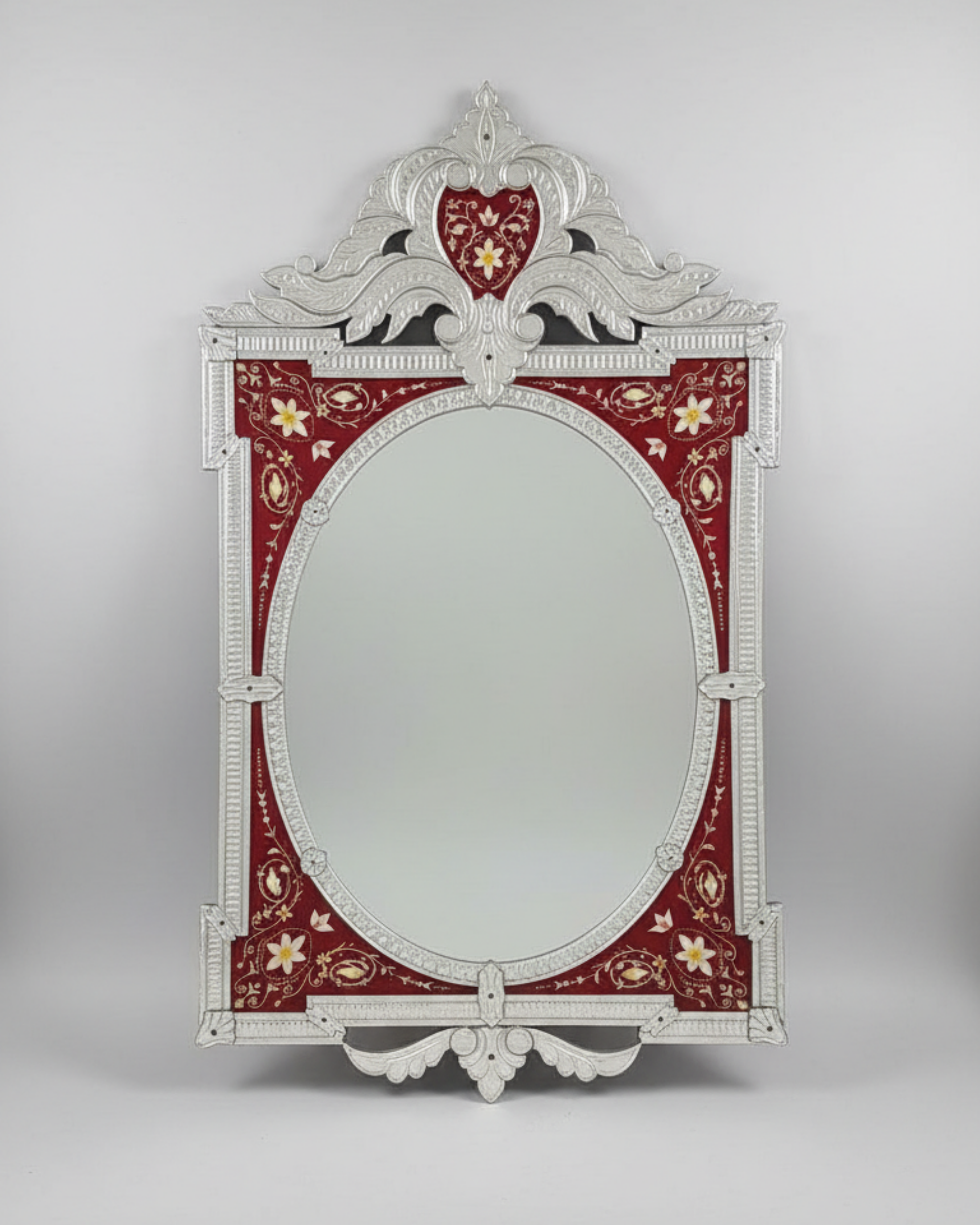 Decorative mirror with a red and gold frame on a gray background