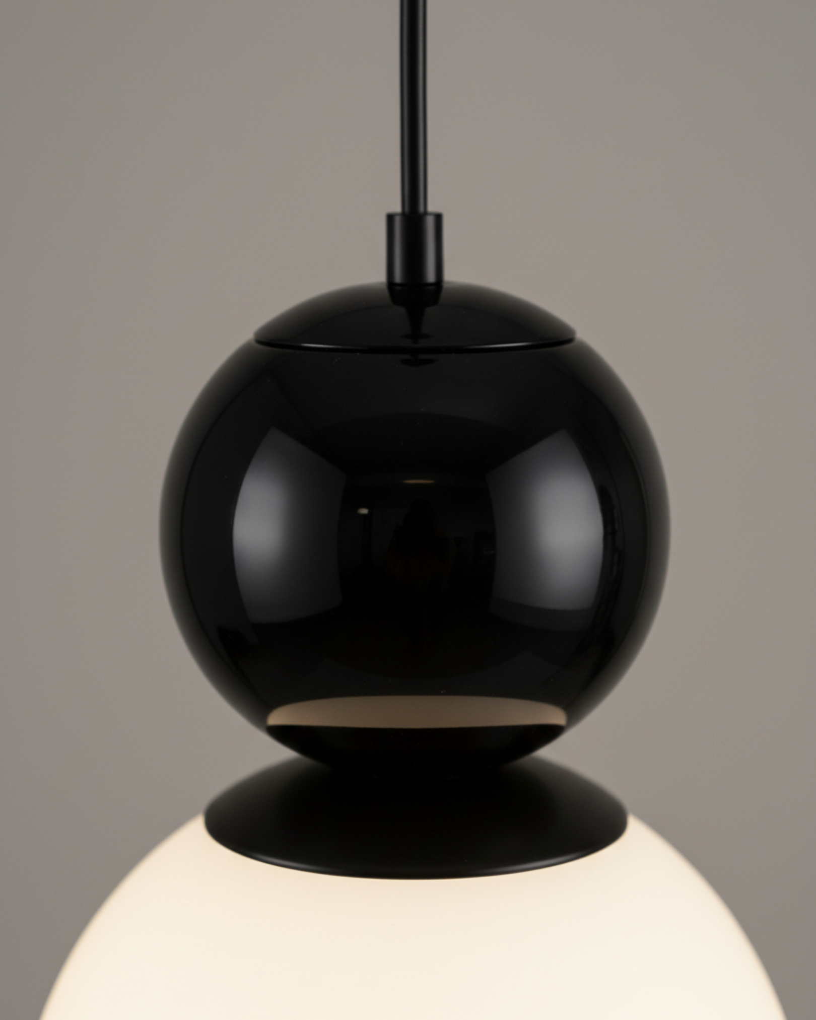 Black pendant light with a gray background the Noor Orb Pendant Light is a statement of understated luxury. The design features a luminous handcrafted glass sphere, framed gracefully by solid brass accents that add warmth, contrast, and durability.