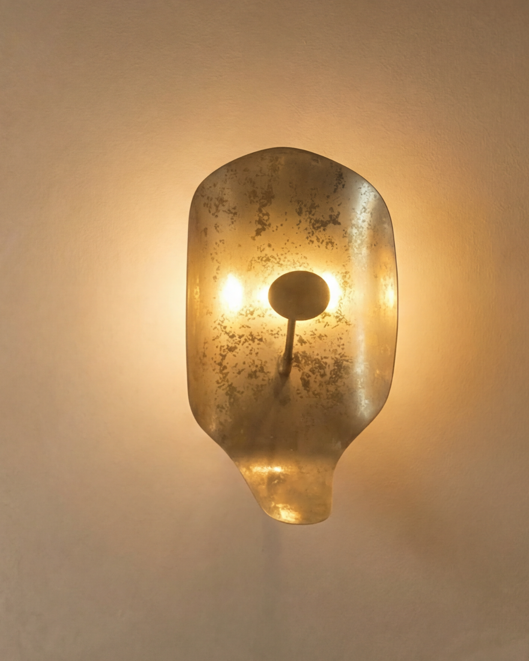 Decorative wall sconce with a textured glass shade on a neutral background