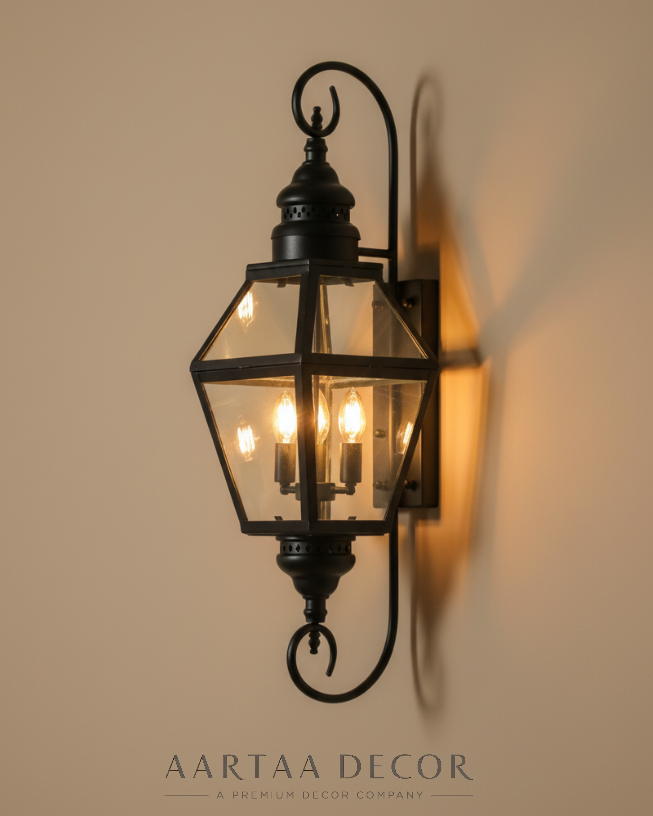 Decorative wall sconce with glass cover on a beige wall, featuring the brand 'Aartaa Decor'.