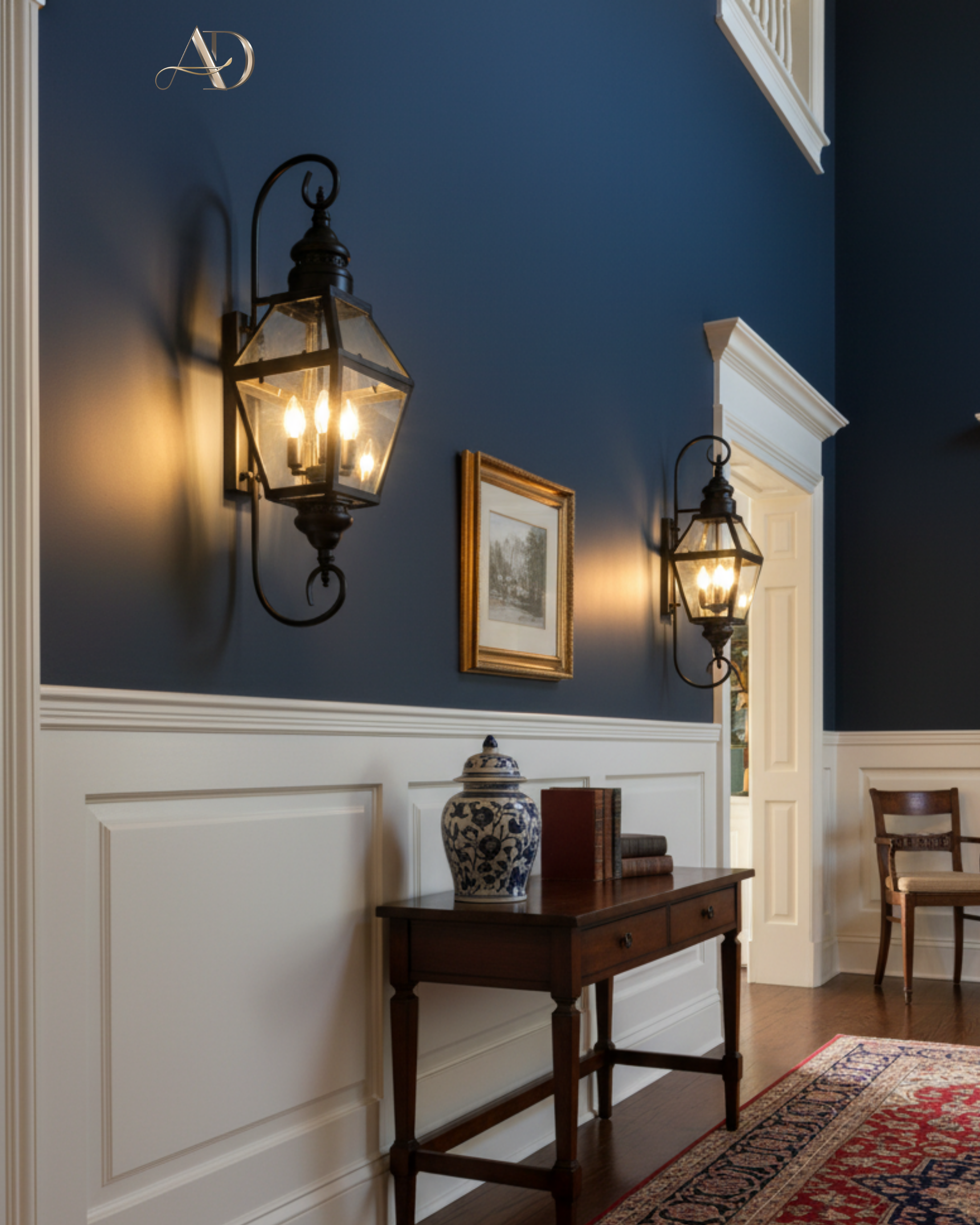 Narrow hallway with dark blue walls, white wainscoting, and decorative lighting fixtures.