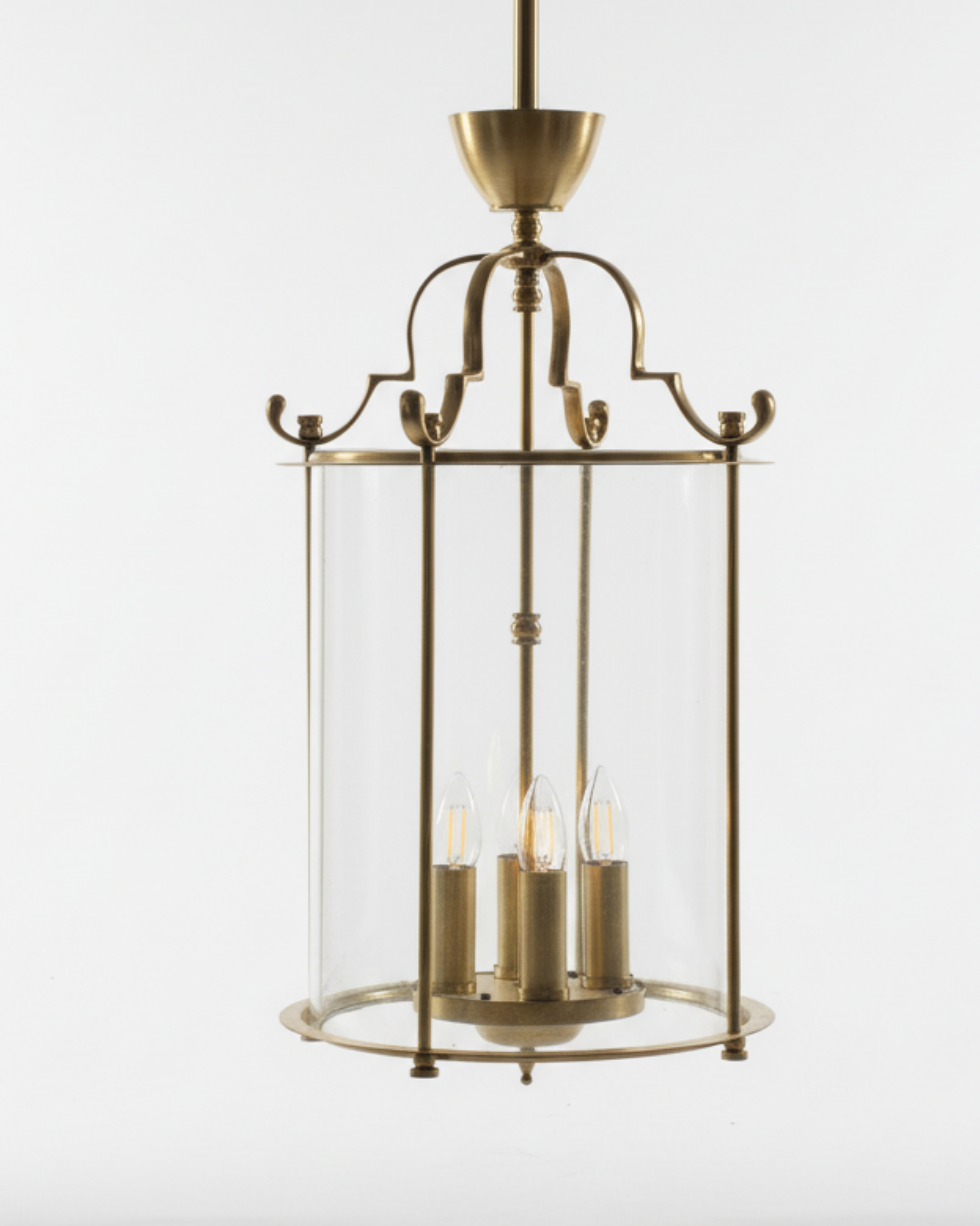 Angled view of handcrafted brass lantern pendant light featuring antique brass finish and cylindrical glass casing – Aartaa Decor premium lighting