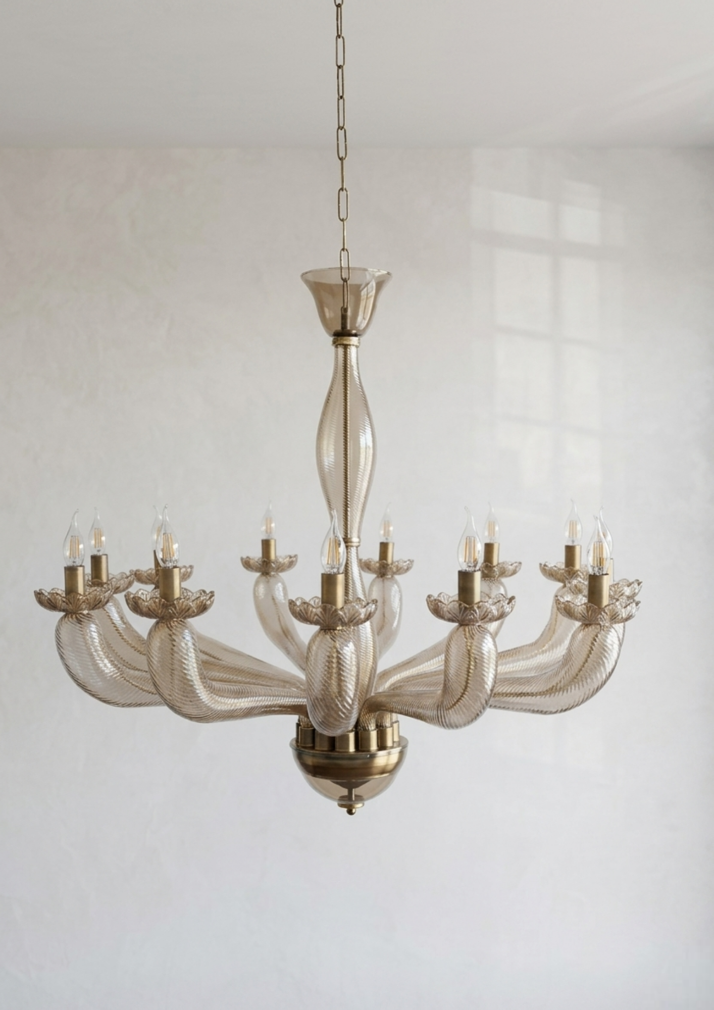 Decorative chandelier with glass shades and brass accents against a neutral background